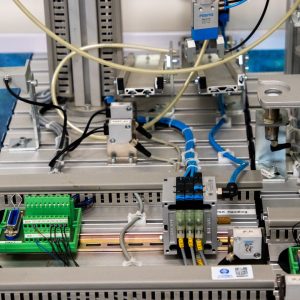 Close-up of industrial equipment showcasing electronic wiring and sensors in a manufacturing setup.